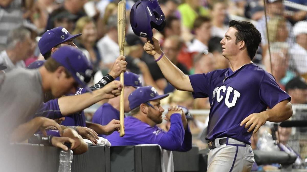 TCU’s Josh Watson is greeted at the dugout after scoring a run in the fifth inning of Tuesday night’s College World Series game against Coastal Carolina.