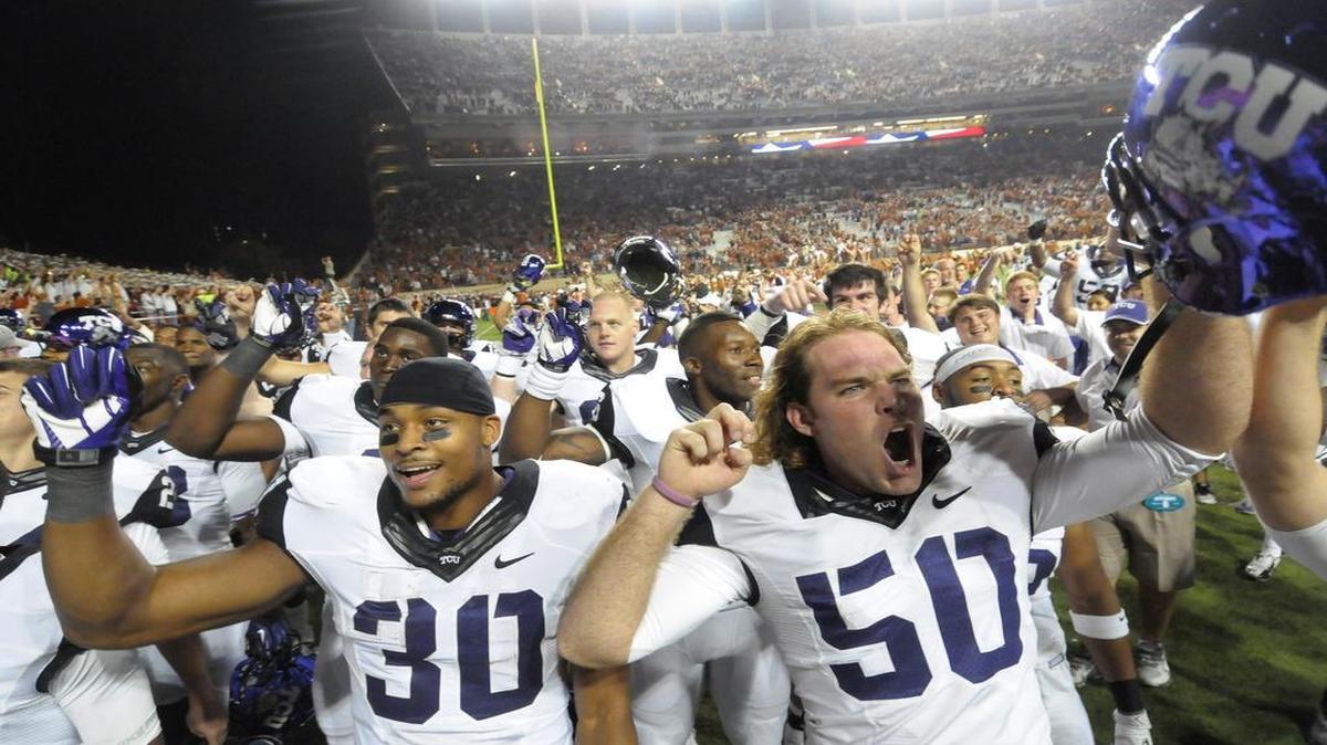 TCU running back Aundre Dean, left, and long snapper Daniel Shelley sing the school song after the Horned Frogs 20-13 win against No. 16 Texas in Austin on Thanksgiving night.