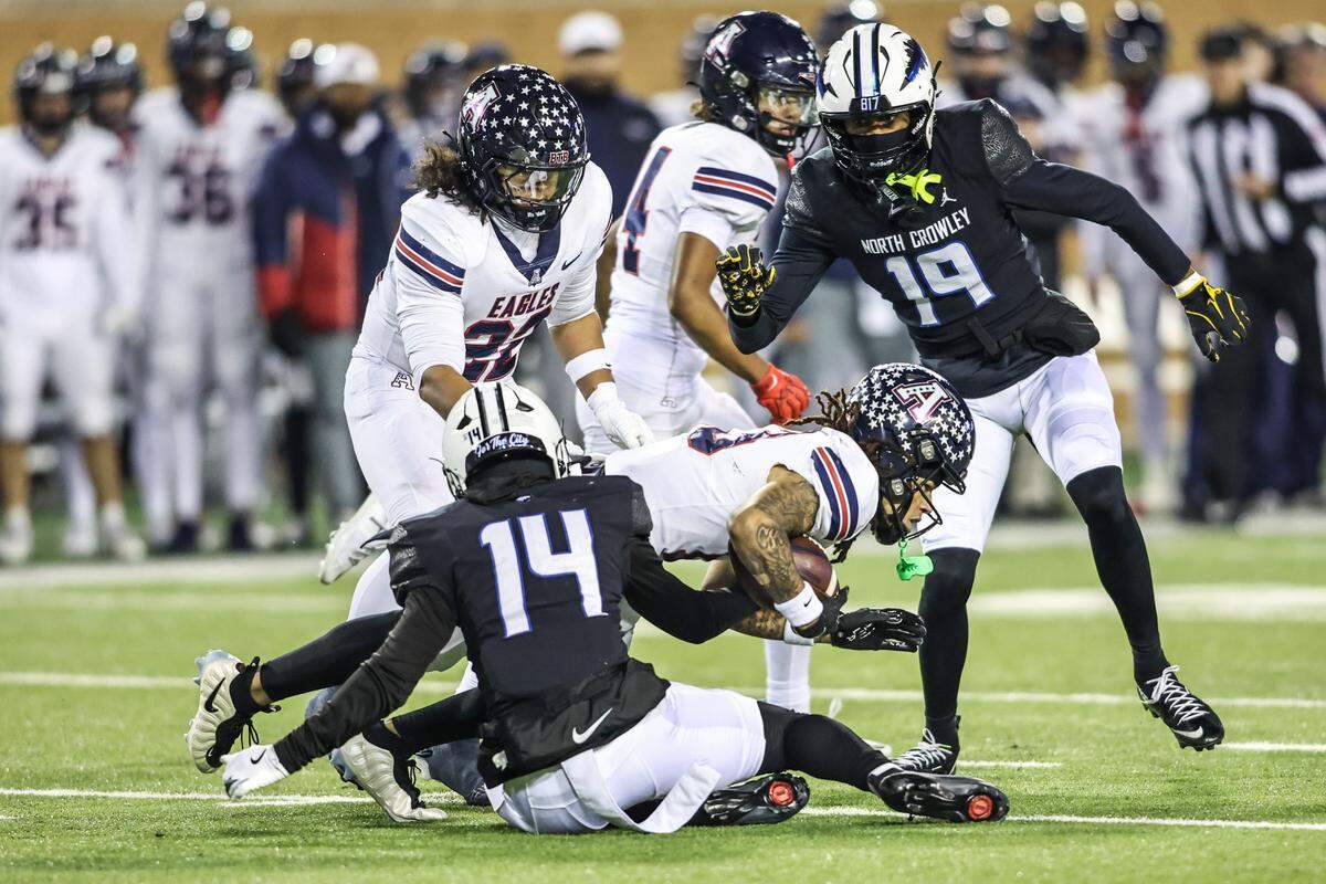North Crowley’s Zion Miller (14) tackles Allen’s LeBron Bauer (13) during the Class 6A Division I regional final Friday, Dec. 5, 2025, at DATCU Stadium in Denton.
