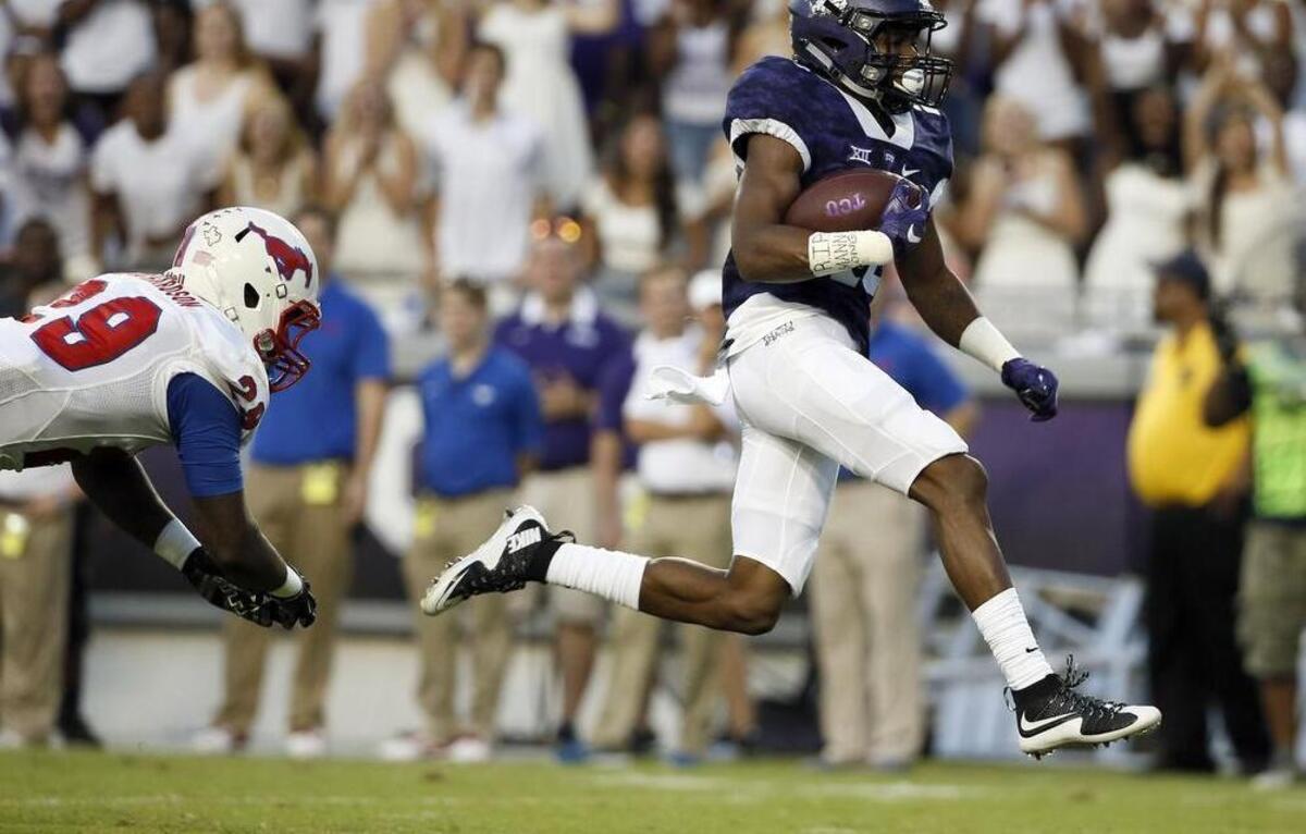 
TCU receiver Kavontae Turpin escapes SMU’s Darrion Richardson on the way to a 61-yard touchdown in the first half.
