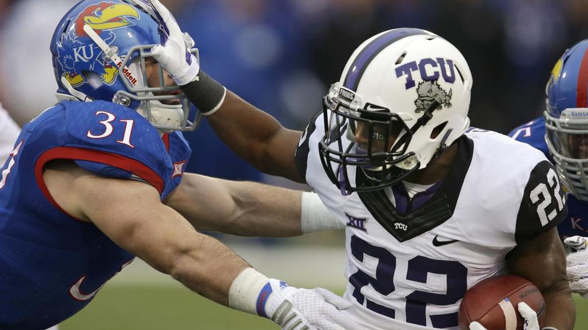 TCU running back Aaron Green stiff arms Kansas linebacker Ben Heeney during action in a Nov. 15, 2014, game at Kansas. The Horned Frogs won 34-30, the first of three consecutive games decided by single digits in the series.
