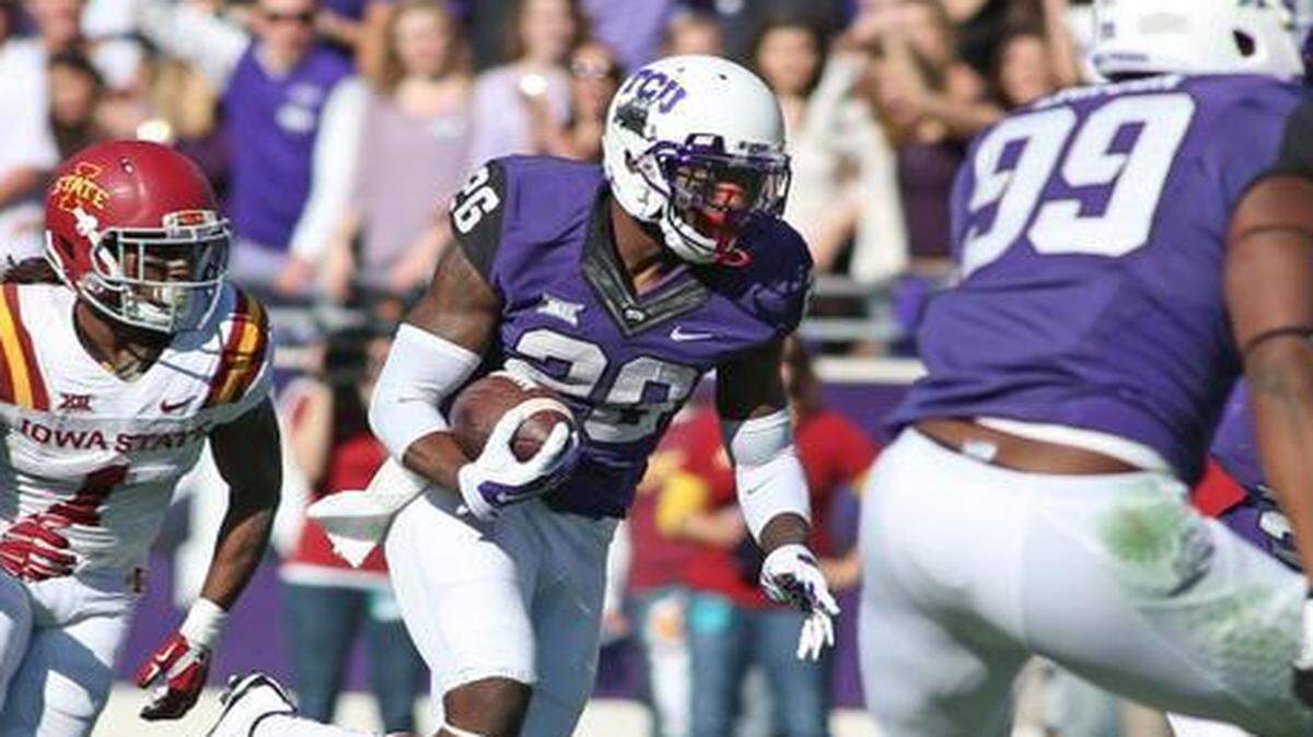 
TCU safety Derrick Kindred takes back an interception against Iowa State behind the blocking of defensive tackle Tevin Lawson. They are two of the players the Horned Frogs are counting on to build a defense for 2015 as spring practices begin Saturday.
