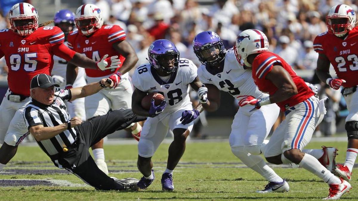 TCU receiver Jalen Reagor runs through defenders and an official with a first-quarter reception.