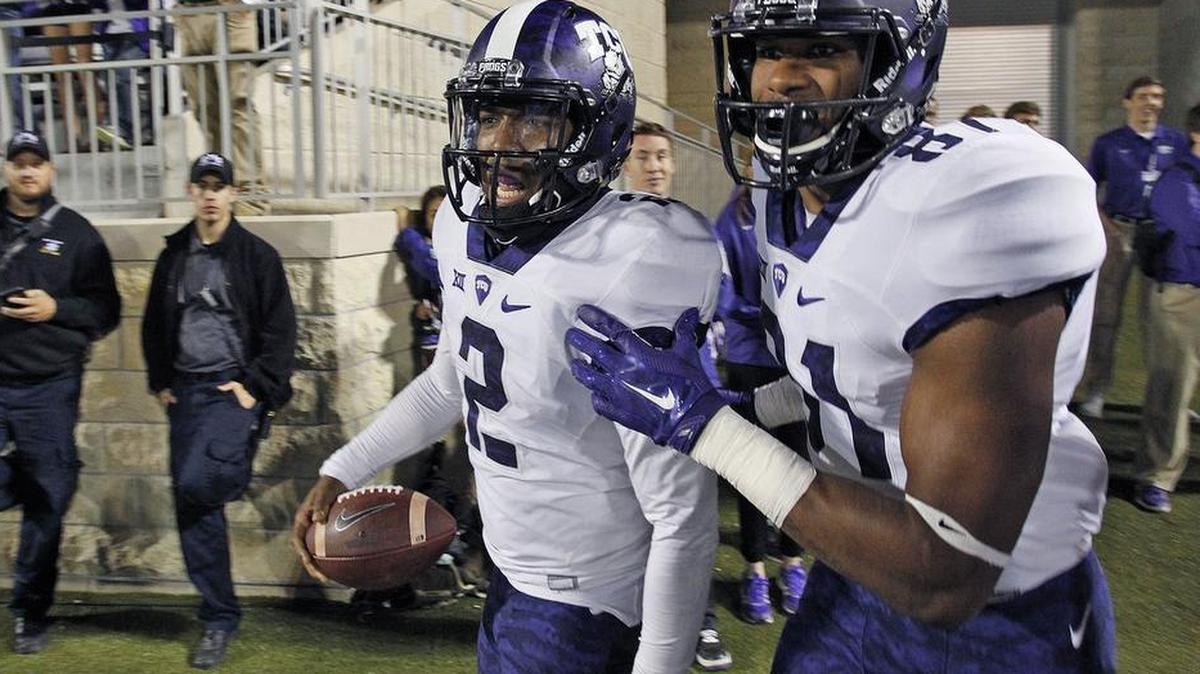 
TCU quarterback Trevone Boykin and receiver Ja’Juan Story head back to the sideline after celebrating Boykin’s 69-yard touchdown run against Kansas State. It was one of two touchdown runs in the fourth quarter by Boykin that rallied the Horned Frogs to a 52-45 victory.
