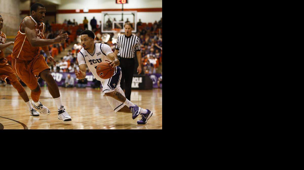 
TCU guard Kyan Anderson, driving by Texas forward Jonathan Holmes, was held to two points against the Longhorns on Monday.
