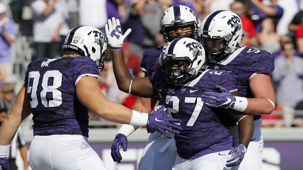 TCU running back Derrick Green (27) is congratulated by teammates, including linemen Casey McDermott Vai (98) and Austin Schlottmann following a touchdown against Texas Tech on Oct. 29 at Amon G. Carter Stadium.