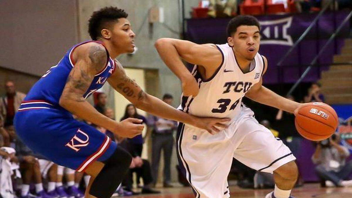 
TCU forward Kenrich Williams, right, tries to get around Kansas guard Kelly Oubre Jr. in the first half. 
