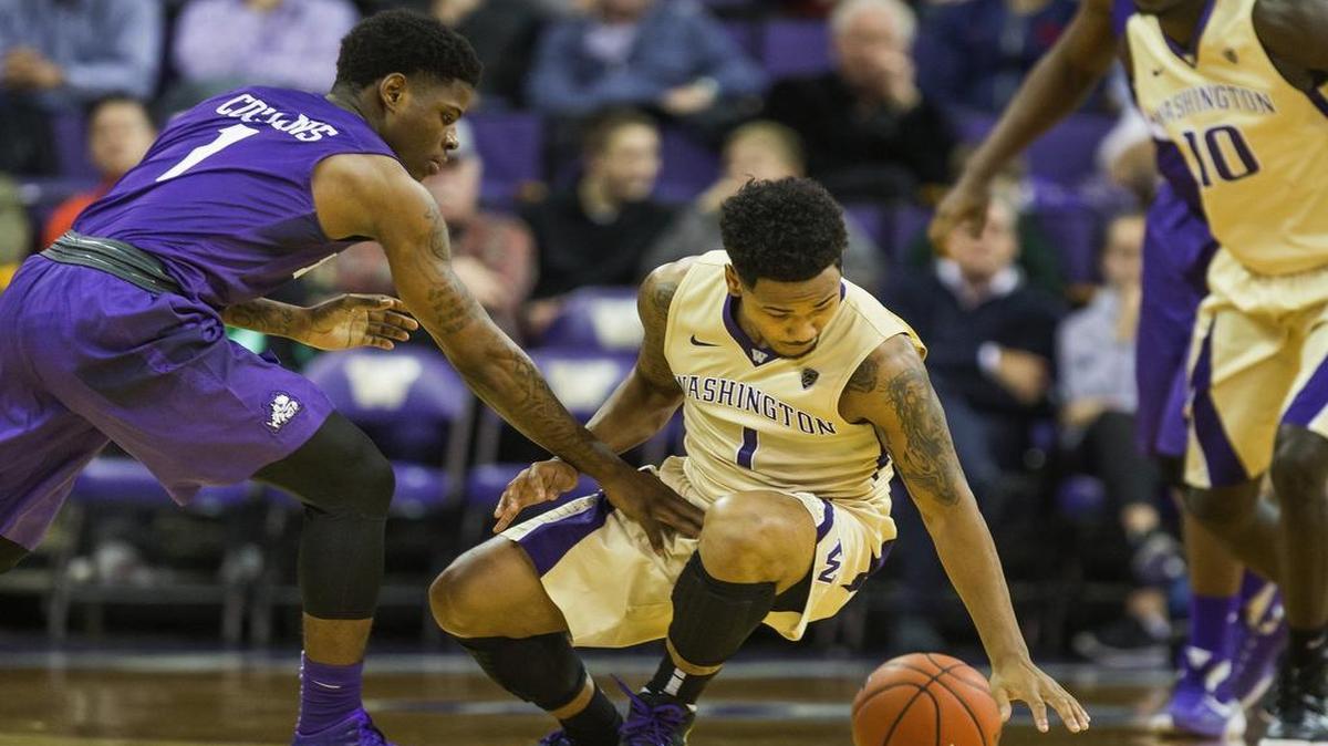 TCU’s Chauncey Collins, left, in his first game back from a leg injury, scrambles for a loose ball with Washington’s David Crisp during Tuesday’s game in Seattle.