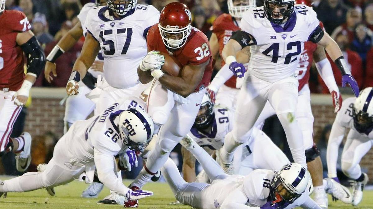 Oklahoma running back Samaje Perine runs between TCU safeties Derrick Kindred and Nick Orr.
