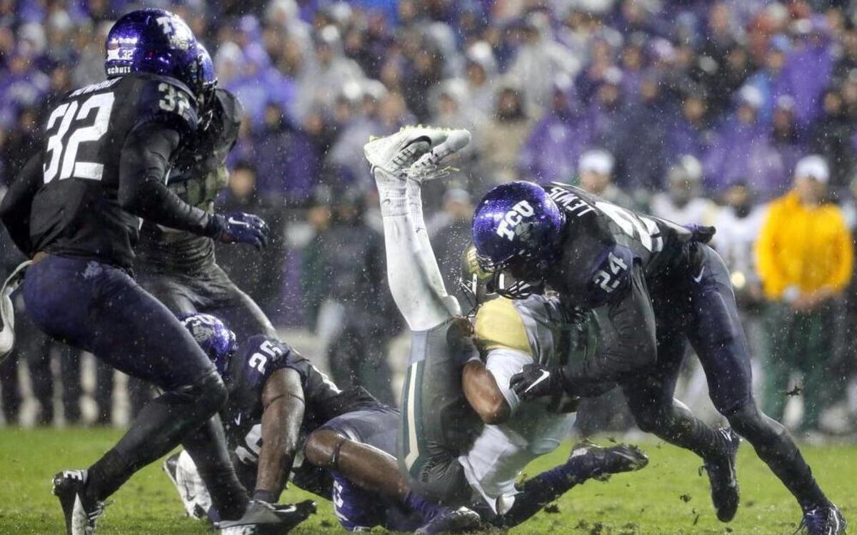 TCU safety Travin Howard (32) watches as safety Derrick Kindred (26) and cornerback Julius Lewis (24) combine to tackle Baylor quarterback Chris Johnson (13), bending him in half, after a short gain on Nov. 27, 2015, in Fort Worth. TCU is adjusting its defense after numerous injuries have affected the Horned Frogs returners.