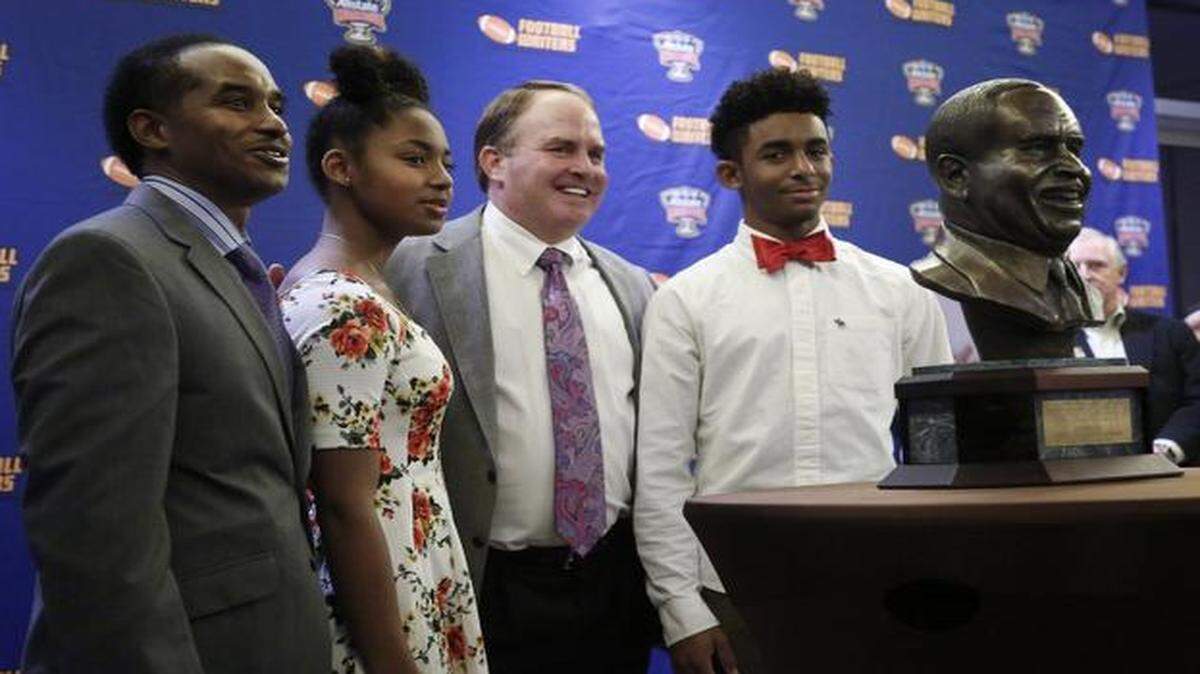 
TCU coach Gary Patterson, middle, is joined by Eddie Robinson family Saturday in Dallas.
