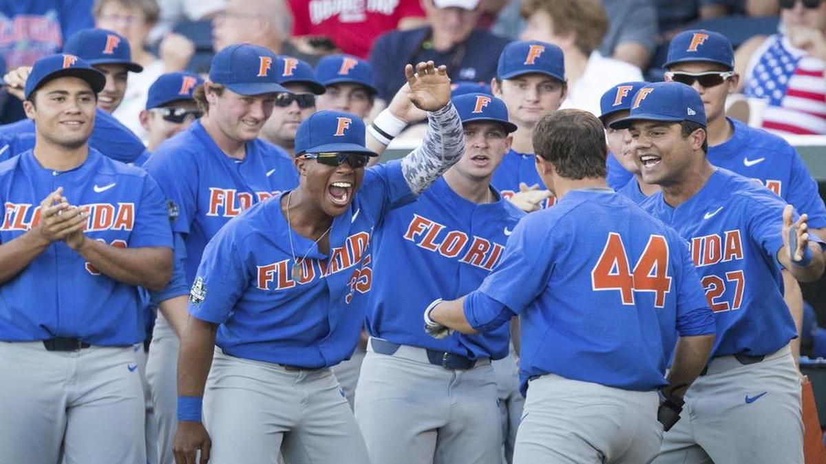 Florida teammates greet Austin Langworthy after he smashed a solo home run in third inning of Tuesday’s 5-1 victory over Louisville at the College World Series.