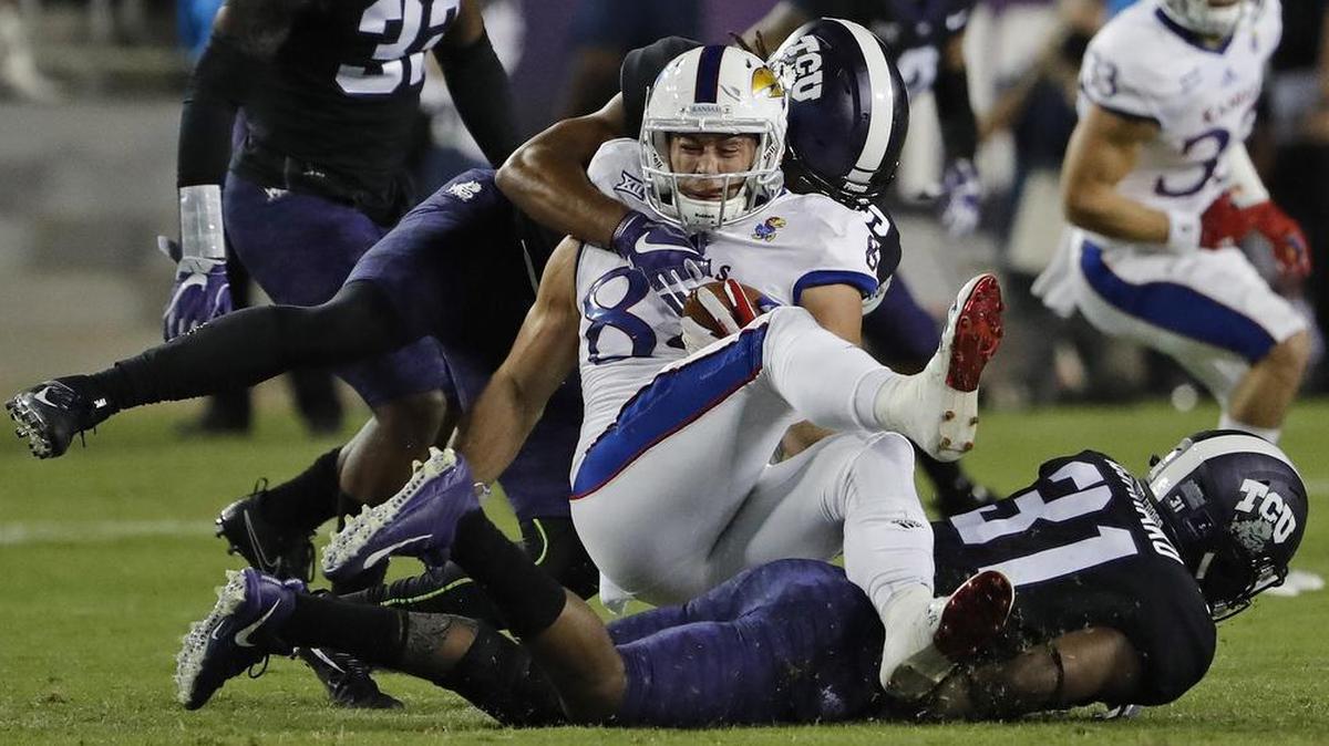 Kansas tight end Ben Johnson (84) is brought down by a swarming TCU defense in the first quarter of Saturday’s game.