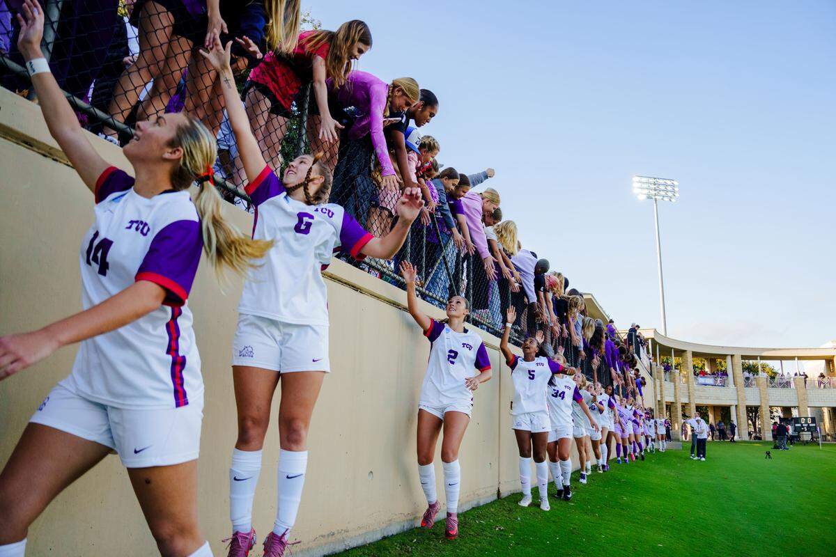 TCU women’s soccer players celebrate with fans after the victory over North Carolina.