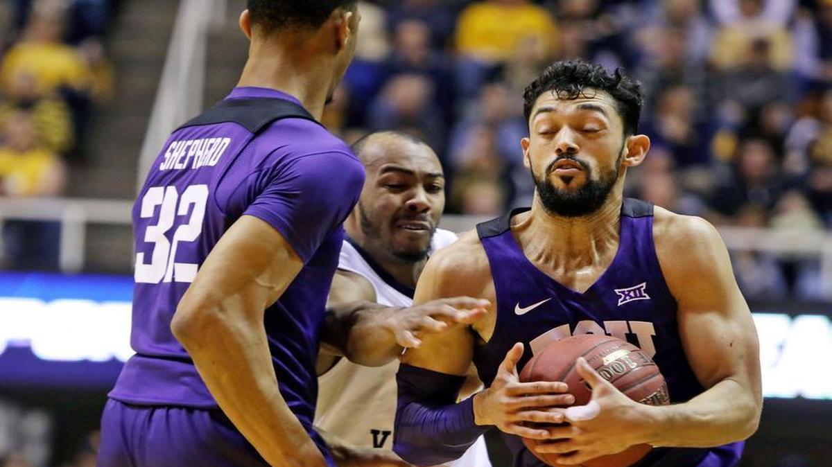 West Virginia guard Jevon Carter, center, attempts to steal the ball from TCU guard Alex Robinson (25) during the second half of an NCAA college basketball game, Saturday, Jan. 7, 2017, in Morgantown, W.Va.