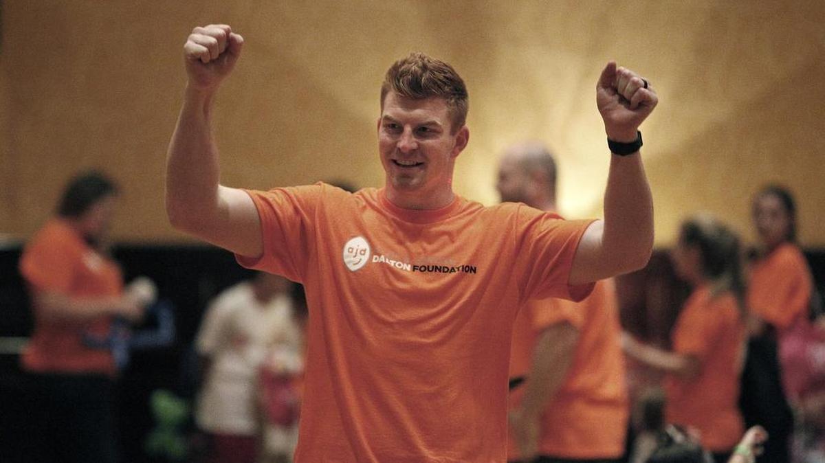 Andy Dalton celebrates a catch made by one of the children enjoying a play day Wednesday at the Worthington Hotel in Fort Worth.