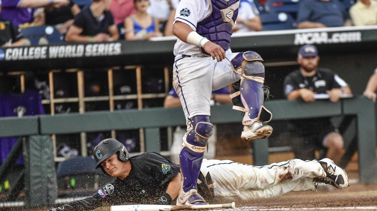 Coastal Carolina’s Anthony Marks scores behind TCU catcher Evan Skoug on a bunt by Billy Cooke in the third inning.