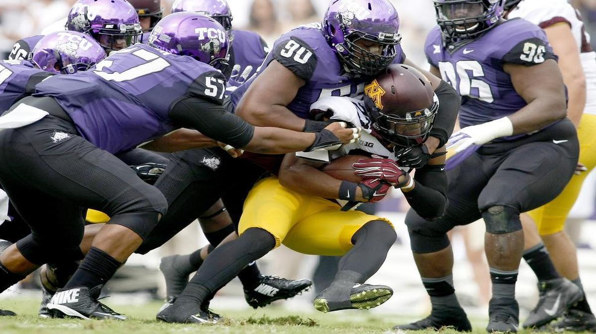 
The TCU defense, led by defensive end Terrell Lathan, stops Minnesota running back David Cobb on a third-down play in last year’s game in Fort Worth.
