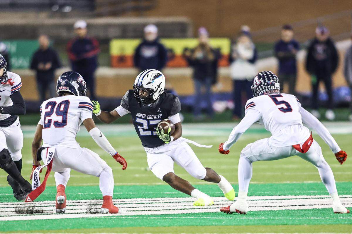 North Crowley running back Kiante Ingram (23) cuts between Allen defenders Kai Wheaton and Jahsxiah Gibson (29) during the Class 6A Division I regional final Friday, Dec. 5, 2025, at DATCU Stadium in Denton.