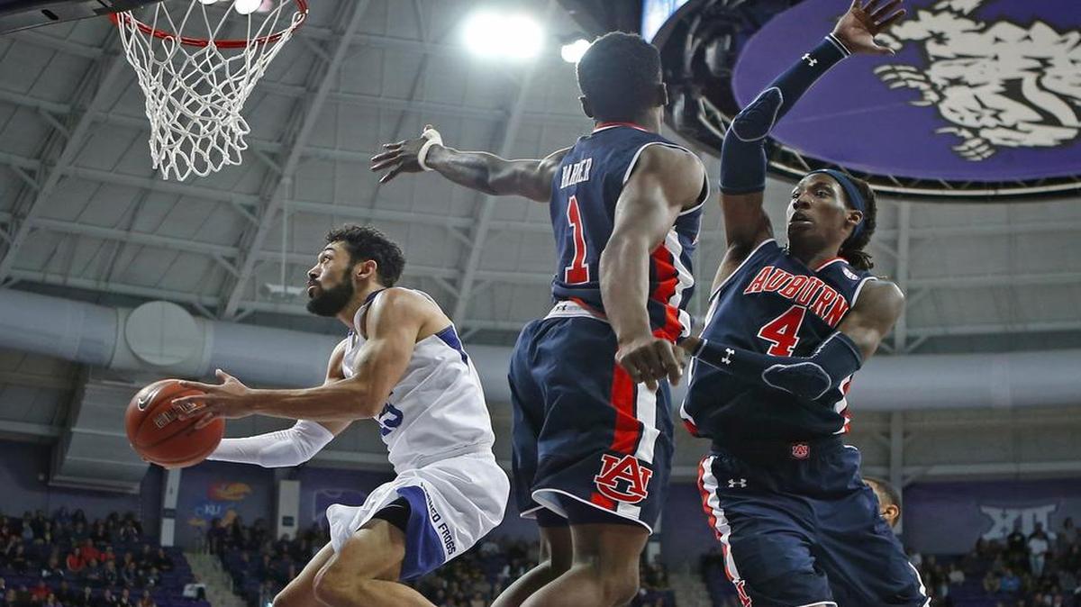 TCU’s Alex Robinson sails past Auburn’s Jared Harper and T.J. Dunans during the Big 12/SEC matchup in January.