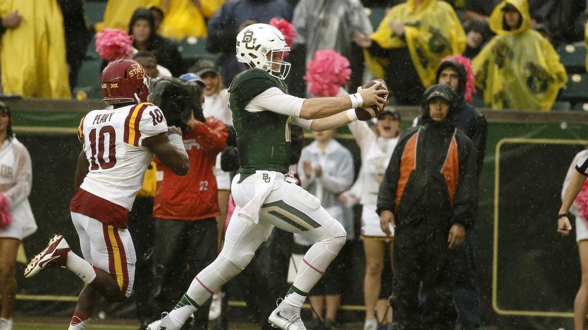 Baylor quarterback Seth Russell races into the end zone ahead of Iowa State’s Brian Peavy for a touchdown Saturday. He left the game in the fourth quarter and later found to have sustained a fracture in his neck.