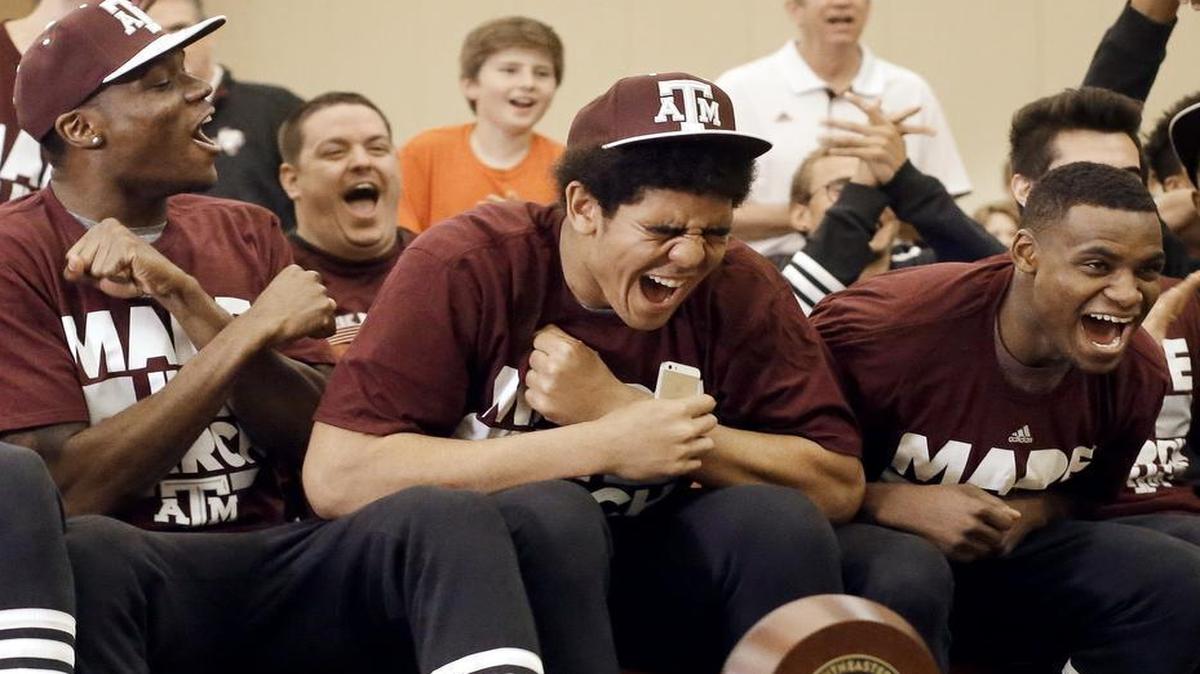 Texas A&M’s Tyler Davis, center, cheers as his team’s selection is announced in the NCAA Tournament Sunday. Texas A&M was selected as the third seed in the West Region in Oklahoma City and will play Green Bay.