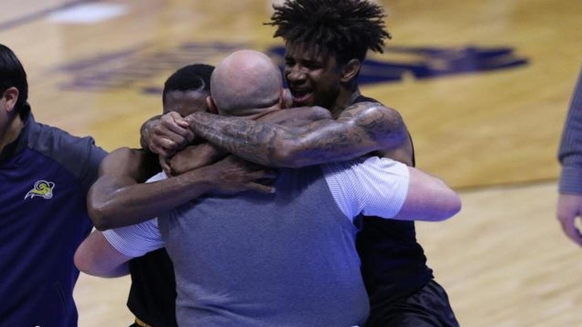 Texas Wesleyan players including Naiel Smith embrace coach Brennen Shingleton after a thrilling 83-82 overtime over William Penn in the NAIA semifinals.