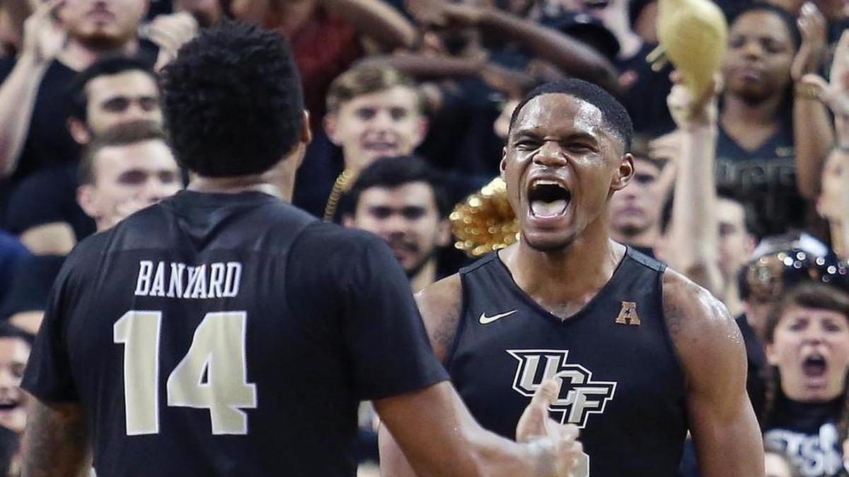 Central Florida’s A.J. Davis, right, celebrates with teammate Nick Banyard (14) during a 68-58 win against Illinois during an NIT Tournament quarterfinal at CFE Arena in Orlando, Fla., on Wednesday.