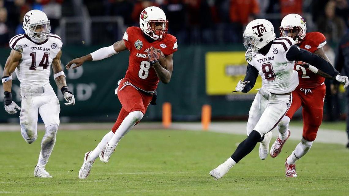 Louisville quarterback Lamar Jackson (8) runs past Texas A&M defenders Justin Evans (14) and Nick Harvey (8) for a 37-yard gain in the second half of the Music City Bowl on Dec. 30, 2015, in Nashville, Tenn. Louisville won 27-21.