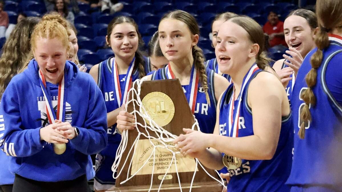 Decatur sophomore Maddyx Coffman holds the Class 4A Division I state championship trophy as teammates celebrate following the Eagles’ overtime win against Waco La Vega on Friday at the Alamodome in San Antonio.