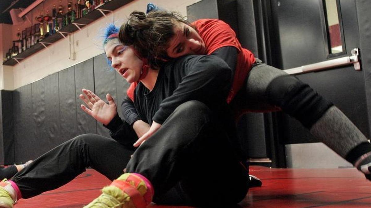 Paisley Zandi attempts to break the hold of LeeAnn Irland during wrestling practice at Trinity High School.