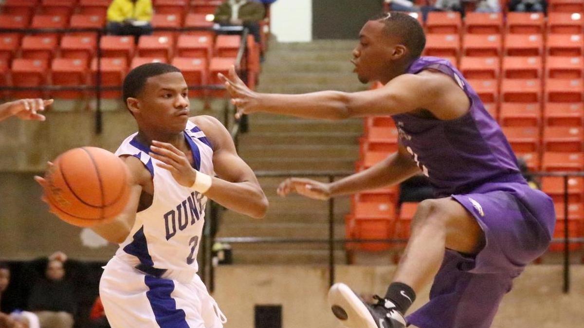 Dunbar’s Jarrod Fields, left, looks to pass the ball as Everman’s Brandon Cookie defends in a basketball game at Wilkerson-Greines AC in Fort Worth, December 28, 2015.
