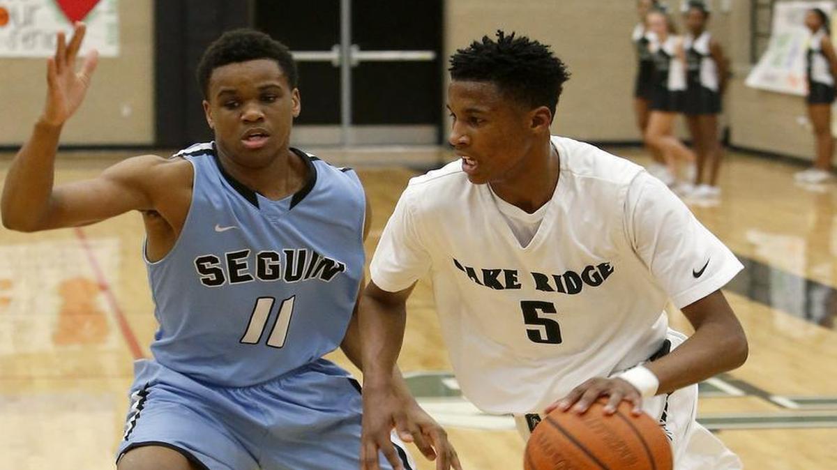 Lake Ridge Eagles guard Tyrone Hugue (5) drives around Arlington Seguin Cougars forward Gray Allison (11) in the first half of high school boys basketball at Lake Ridge High School in Mansfield, Texas on Friday, Feb. 5, 2016.