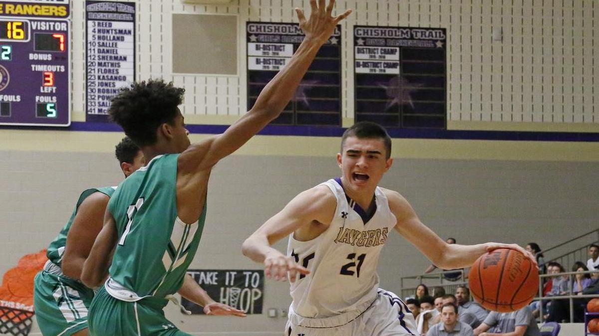 Chisholm Trail guard Ryan Flores (21) sizes up two Azle defenders, Jan. 20, 2017.