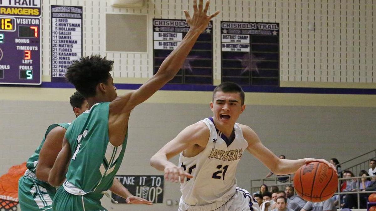 Chisholm Trail guard Ryan Flores (21) sizes up two Azle defenders, Jan. 20, 2017.