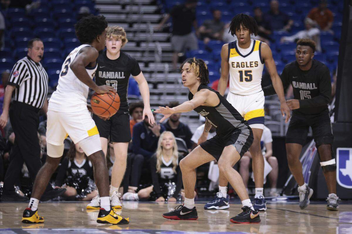 Dallas Oak Cliff Faith Family’s Jazz Henderson (3) looks to get the ball inside to Jadyn Toppin (15 in white) as Amarillo Randalll’s J.J. Buchanan (4), Brody Wilson (13) and Devin Baccas (15 in black) defend in the Class 4A state semifinals on Friday, March 10, 2023 at the Alamodome in San Antonio, Texas.