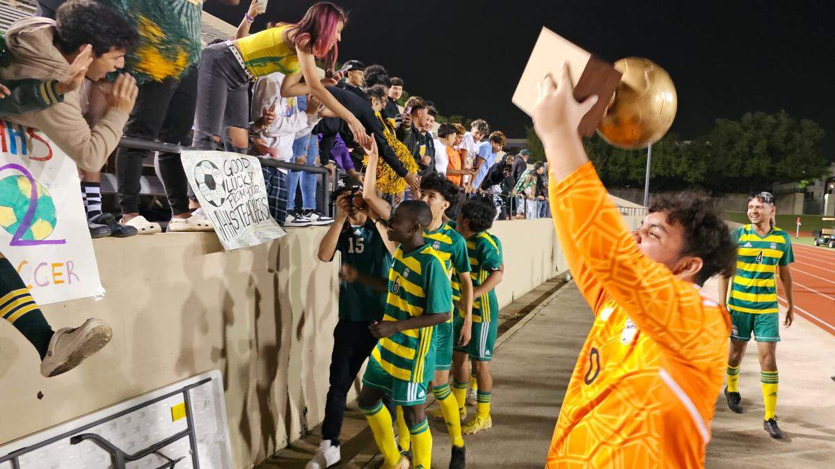 Fort Worth Western Hills goalkeeper Jorge Urbina hoists the Class 4A Region I quarterfinal trophy as his teammates greet fans after defeating Fort Worth Carter-Riverside on Friday, March 31, 2023 at Farrington Field in Fort Worth.