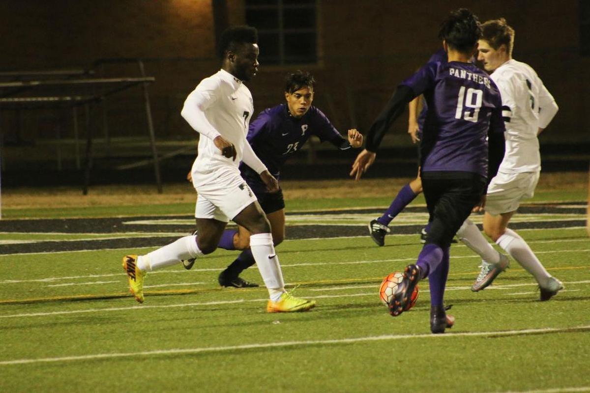 Arlington forward Prince Okegbe (7) and teammate Luis Aguilar (6) converge on the ball as Paschal High players close in.