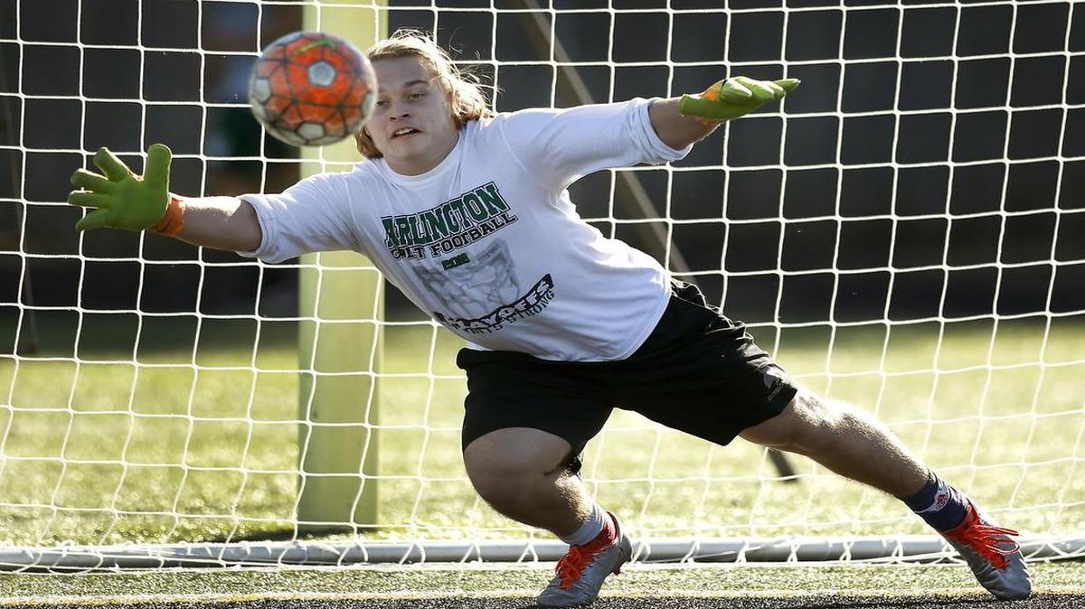 Arlington High boys soccer goalie Ben Carroll deflects a shot during practice at the school in Arlington, Texas on Monday, Jan. 23, 2016.