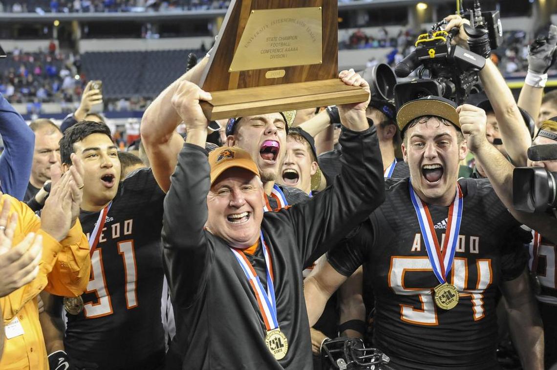 Aledo coach Steve Wood holds the 5A Division I high school football championship trophy after the Bearcats defeated Temple in 2014.