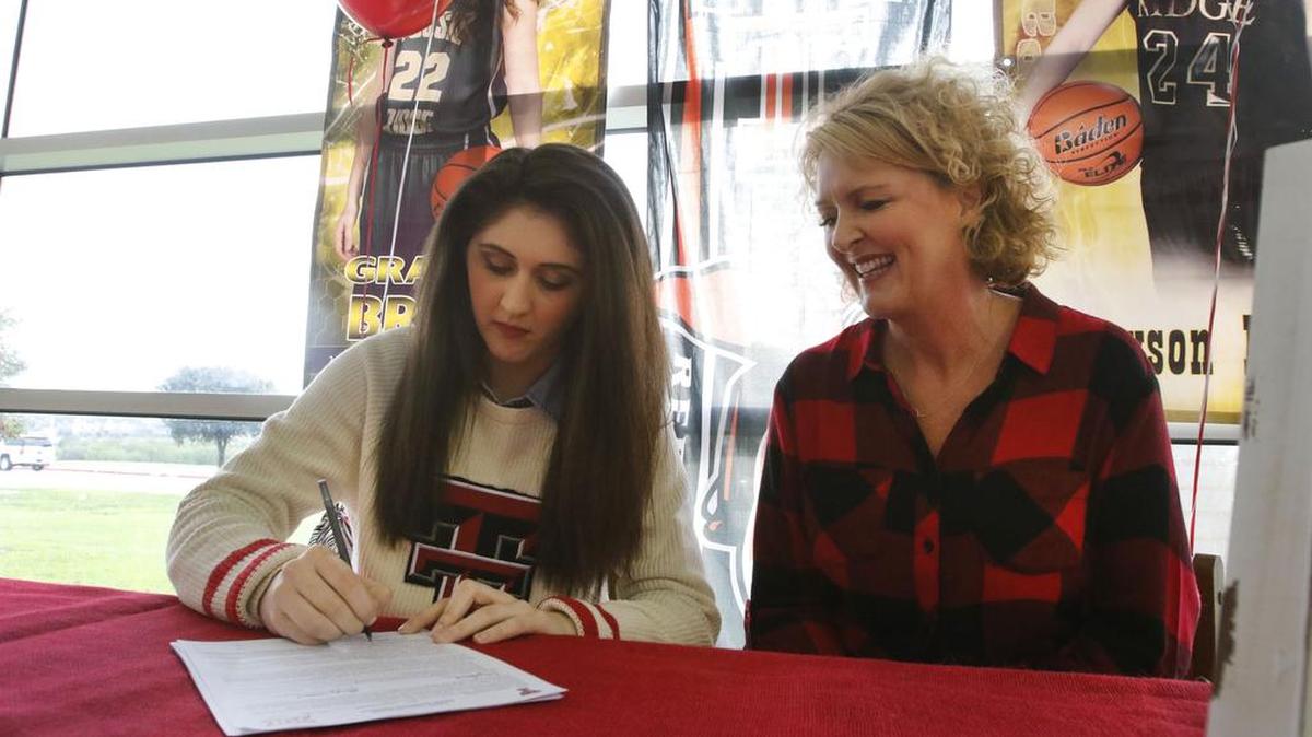 Fossil Ridge High School senior Grayson Bright signs her letter of intent to play basketball at Texas Tech as her mother DeAnne Bright looks on at the school in Fort Worth, Texas on Wednesday, Nov. 11, 2015.
