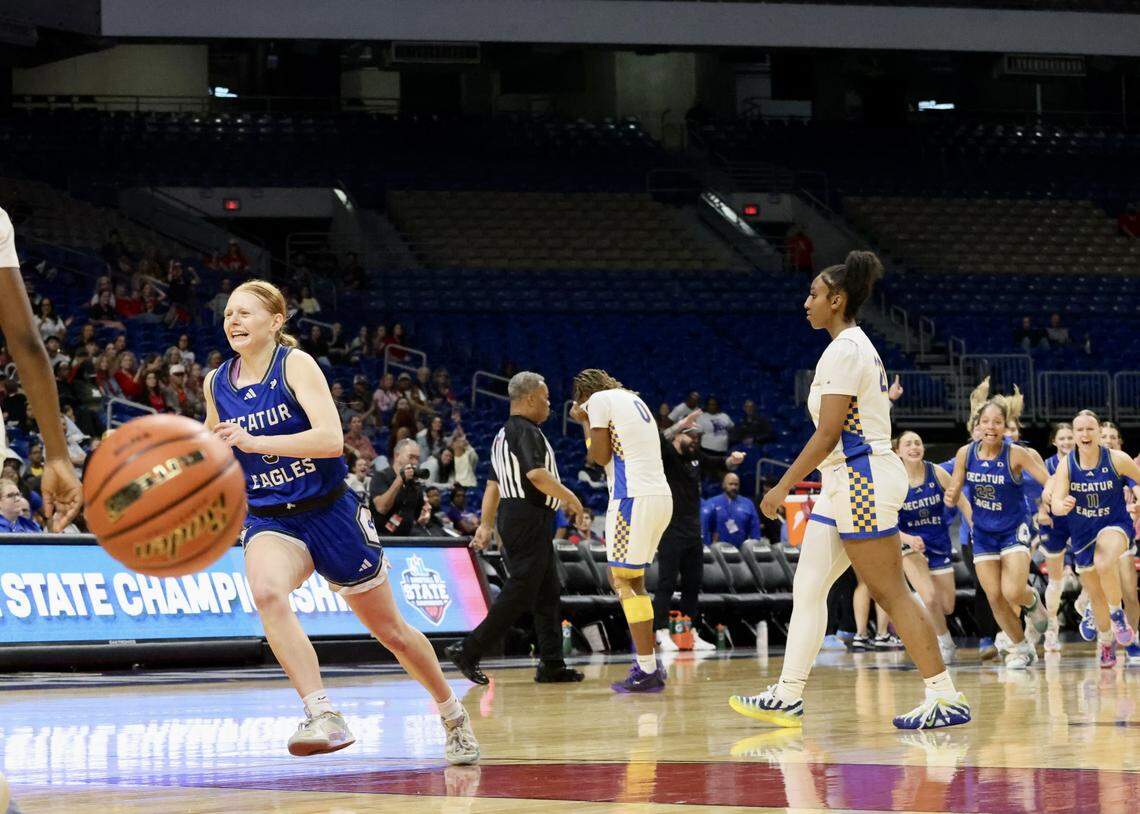 Members of the Decatur Eagles basketball team run toward the victory pile just after the final buzzer of their 58-54 overtime victory over Waco La Vega in the Class 4A Division I state championship game Friday at the Alamodome in San Antonio.