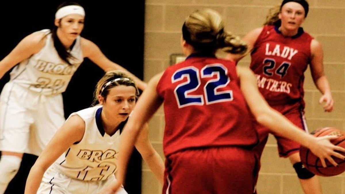 Brock guard Trisha Jacobs (13) defends Alba-Golden’s Caitlin Lennon (22) in regional semifnal action, while Brock post Allie Popeck (32) covers Gracie Pendergrass (24).