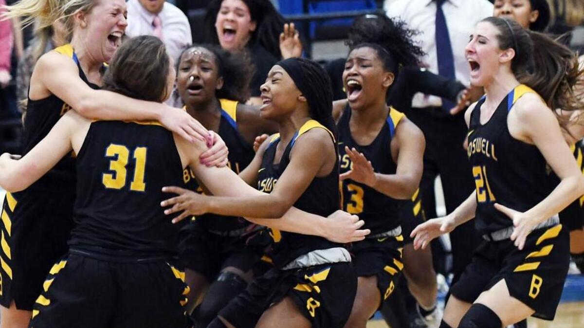 Saginaw Boswell forward Audrey Warren (31) is embraced by teammates afer making a 3-pointer at the buzzer to force overtime against Birdville, Feb. 17, 2017.