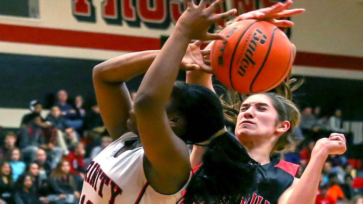 In a January, 26, 2016 game, Trinity guard Kayla Hunter (12) draws defensive coverage from Colleyville Heritage guard Caitlyn Foster (20).