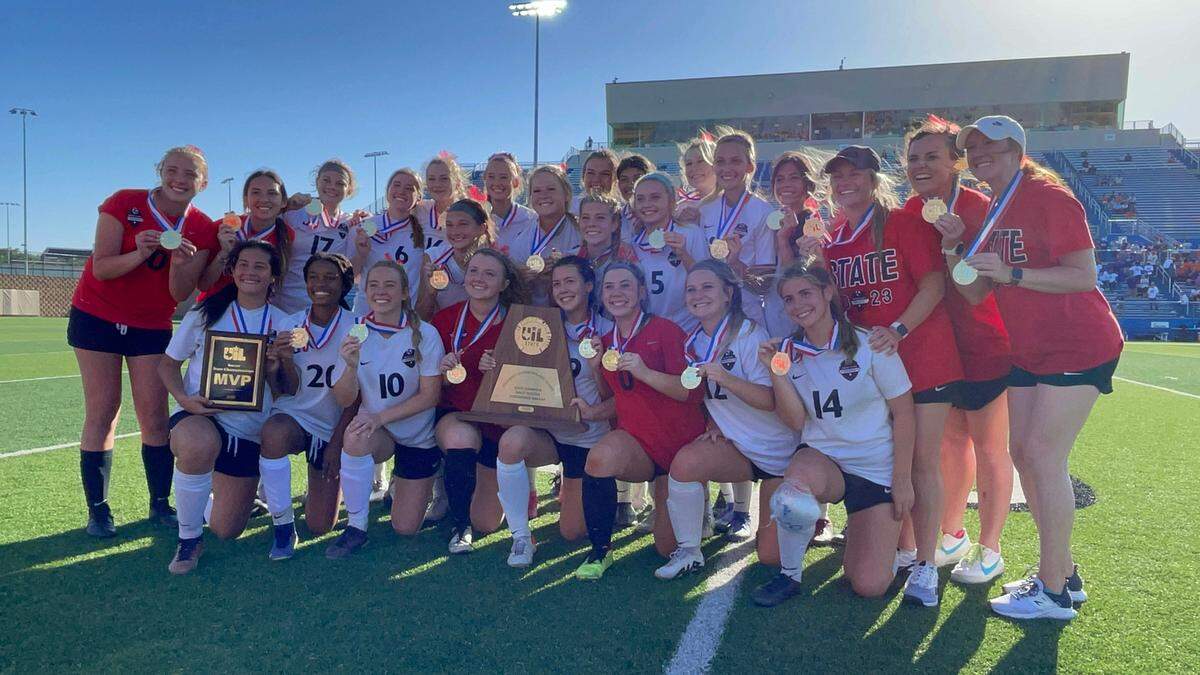 The Flower Mound Marcus girls soccer team poses with hardware after winning the Class 6A state championship 2-0 over Missouri City Ridge Point on Saturday, April 15, 2023 at Birkelbach Field in Georgetown, Texas.