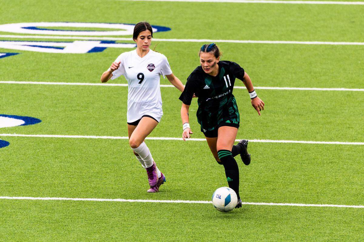 Southlake Carroll’s Kamdyn Fuller (11) races past Flower Mound Marcus’ Maddie Hayes (9) during the Class 6A Region I final on Saturday, April 8, 2023 at McKinney ISD Stadium in McKinney, Texas. Marcus won 1-0 on an own goal.
