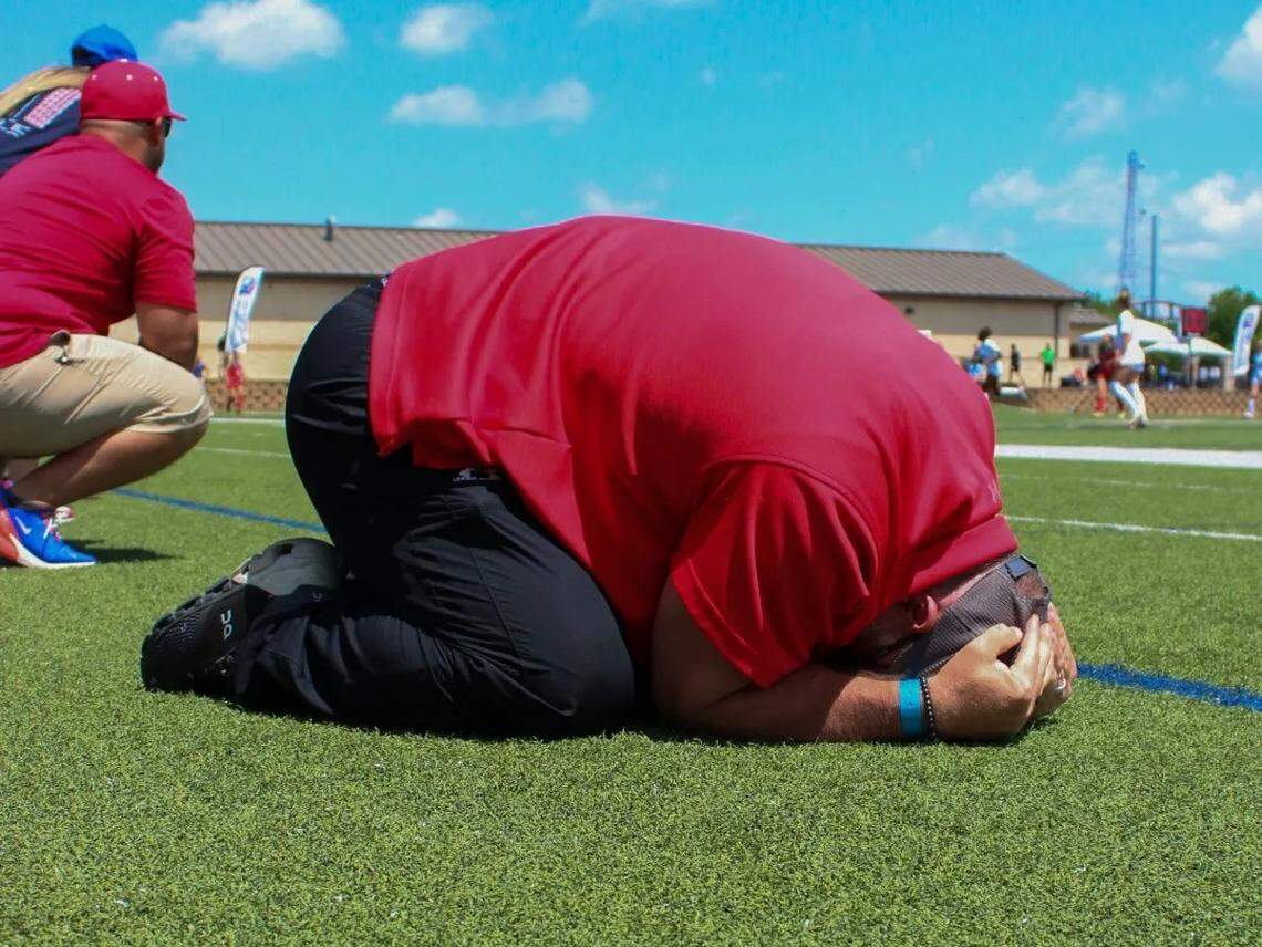 Grapevine coach Steve McBride falls to the ground after the final buzzer sounds in the Mustangs’ win over Frisco in the girls Class 5A state championship game on Saturday, April 15, 2023 at Birkelbach Field in Georgetown, Texas.