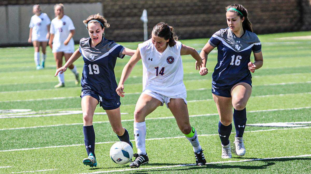 Grapevine’s Theresa McCullough (14), center, battles for space with Smithson Valley’s Emma Siebold (19), left, and Avery Eckert (16), right, in a Class 5A state semifinal on Thursday, April 13, 2023 at Birkelbach Field in Georgetown, Texas. McCullough scored two goals in the Mustang’s win.