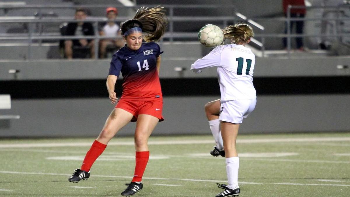 Grapevine’s Christine McCullough (14) heads a ball in district play last season. A new development academy rule could impact the rosters of top teams like the Lady Mustangs next season.